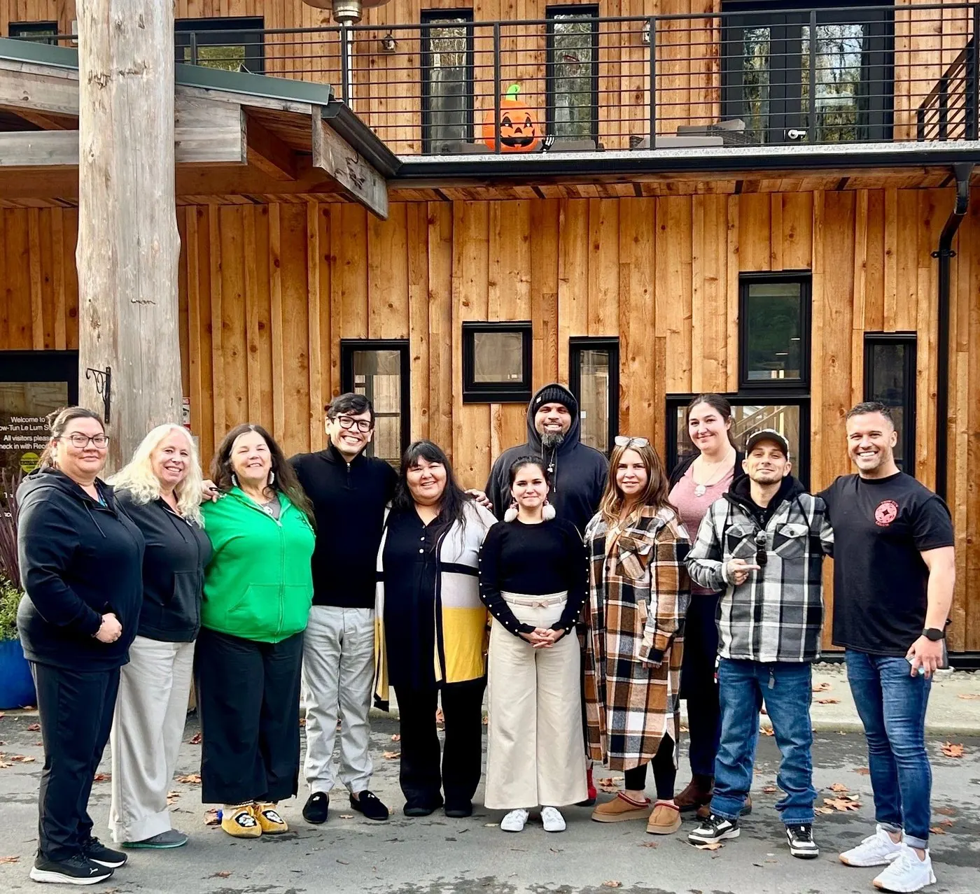 Eli Toombs with a First Nations partner community team outside their community building in Canada